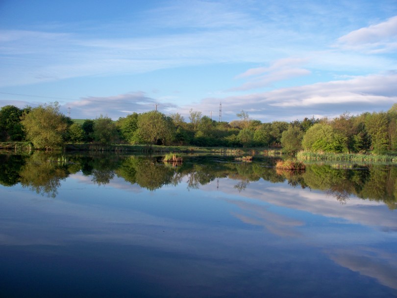 Picture of a lake with a mirror smooth surface in the sunshine