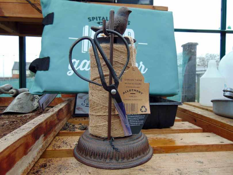 Picture of a string twine holder with a hook for a pair of scissors and a model bird on top